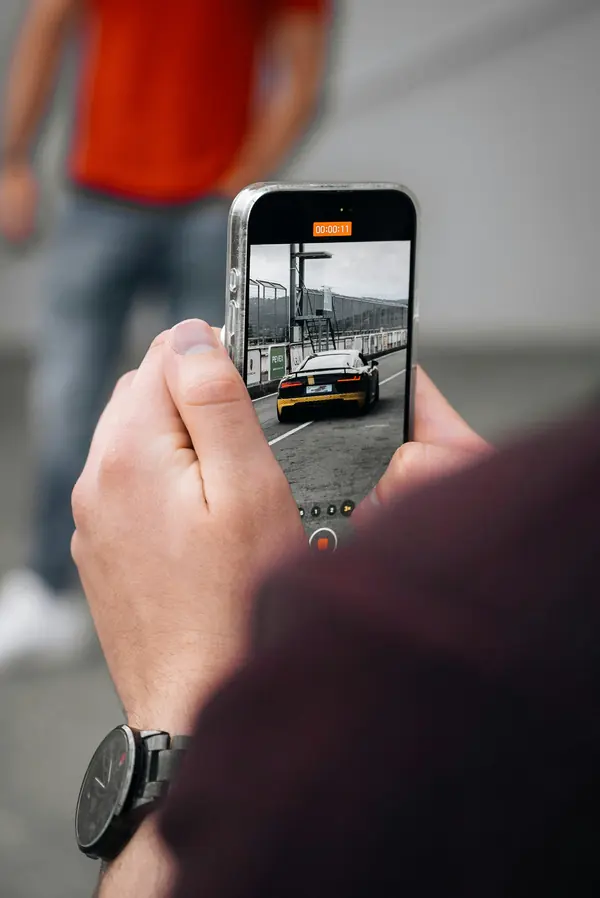 Ein Auto wird mit dem Smartphone fotografiert